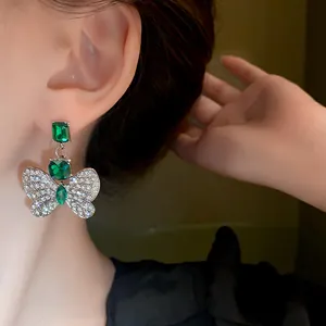 Macro detail of elegant butterfly earring with emerald green crystals and rhinestones