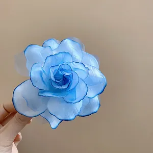 Detaillierte Makroaufnahme einer blauen Kunstrose aus Gaze mit schichtigen Blütenblättern
