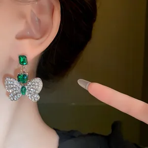 Close-up of elegant green butterfly earrings with sparkling cubic zirconia detailing