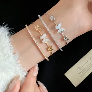 Primer plano de brazaletes de mariposa en oro y plata con detalles de circonia