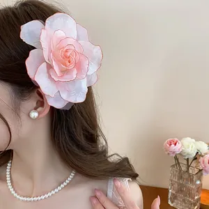 Detailaufnahme einer eleganten rosa Organza-Blumenhaarklammer an einem Modell