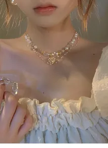 Detailaufnahme einer Vintage-Halskette mit Herzperlen und Kristallen an einem Modell.