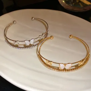 Vista detallada de pulseras huecas de doble capa con mariposas de circón en oro y plata
