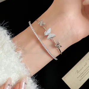 Elegante brazalete de mariposa plateado y pulsera tenis de circonita brillante en la muñeca