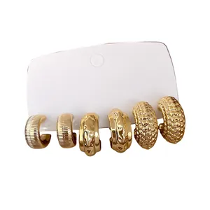 Set de tres pares de pendientes de aro dorados con textura en forma de C de estilo minimalista
