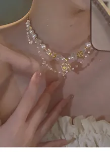 Elegante zweilagige Kette mit Perlen, Kristallen und Herzanhänger an einem Modelhals.
