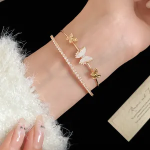 Primer plano del elegante brazalete de circonita de doble capa con mariposas de nácar exquisitas