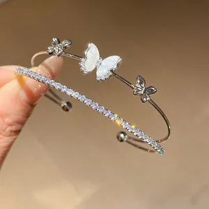 Detalle de pulsera de plata de doble capa con mariposas de circonita y brillo intenso.