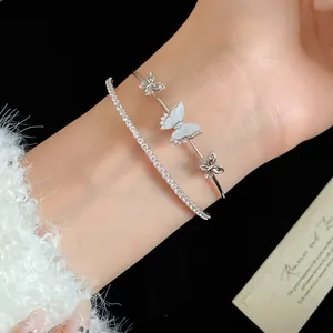 Primer plano de una pulsera de plata de doble capa con mariposas de circón en la muñeca.