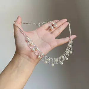 Close-up of vintage pearl fringe necklace and earring set held in hand