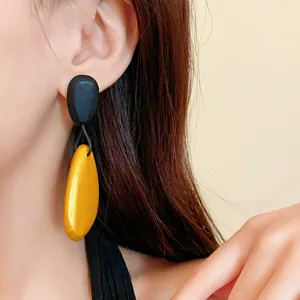 Primer plano detallado de pendientes vintage negros y dorados con forma de gota ovalada