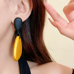 Detalle de los pendientes vintage en forma de lágrima de color negro y dorado
