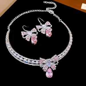 Elegant pink bow zircon necklace and earring set with pearls on black velvet display