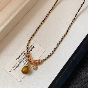 Collier premium plaqué or avec pierre œil de tigre naturelle et breloques en zircon.
