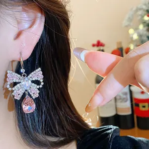 Detailed close-up of an elegant butterfly drop earring with a pink teardrop crystal