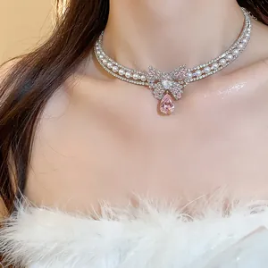 Close-up of elegant pink zircon butterfly choker necklace with pearls for women