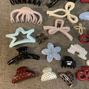 Detail view of various Korean minimalist hair claw clips in assorted colors and shapes.