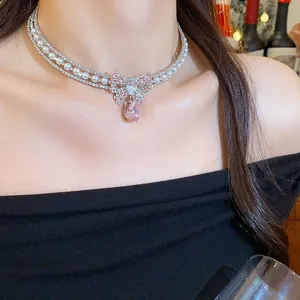 Detailed close-up of a pink zircon bow choker with pearls and a sparkling water drop pendant