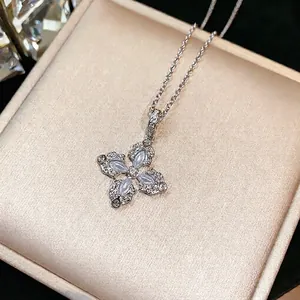 Collana a fiore incrociato in argento con zirconi e intarsi perlati su scatola regalo.