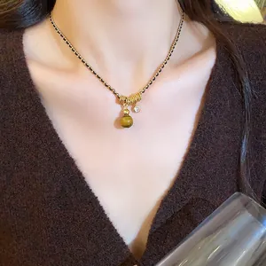 Gros plan détaillé d'un collier en œil de tigre plaqué or avec pendentif en zircon