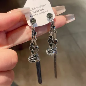 Detailansicht von langen Quastenohrringen aus Silber mit dunkelgrauen Steinen im Design