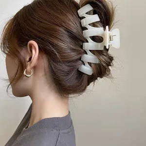 Elegant white spiral claw clip for hair styling in a minimalist premium Korean style.