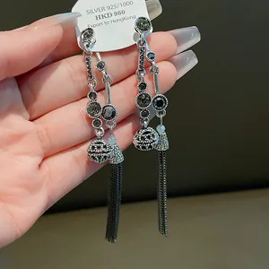 Detailansicht der silbernen Ohrringe im neuen chinesischen Stil mit Quasten und Strass.
