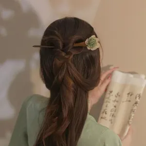 Handgefertigter Holzhaarsieb mit grüner Blume, getragen von einem Modell im Hanfu-Stil