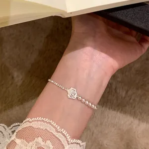 Primo piano dettagliato di un elegante bracciale con rosa, perle e zirconi scintillanti