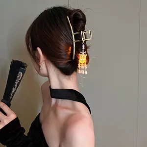 Close-up of glowing palace style hair claw clip with lantern pendant and pearl tassels