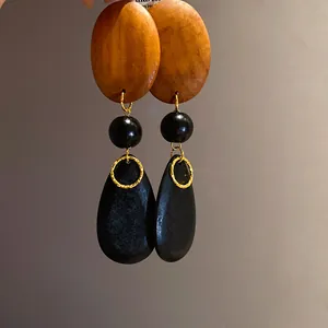 Detailed macro view of vintage style wood bead drop earrings with teardrop shape pendants