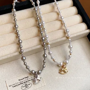 Elegant pearl necklace with gold-plated rocking horse pendant on a soft velvet display tray