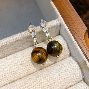 Eleganti orecchini in argento dorato con zirconi e pendenti in perle occhio di tigre