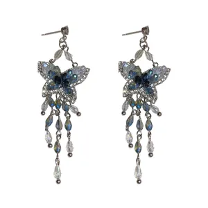 Orecchini a farfalla con nappe, cristalli blu e perni in ago d'argento.