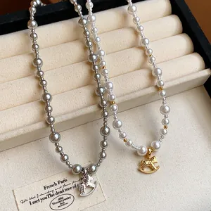 Close-up view of elegant gold and silver rocking horse pendants on pearl necklaces