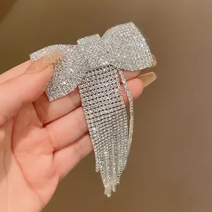 Detailed view of a sparkling rhinestone bow hair clip with elegant dangling crystal tassels