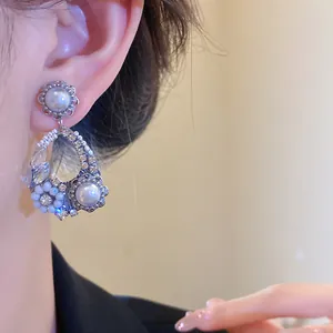 Eleganti orecchini di perle con ago d'argento, cristalli e dettagli floreali all'orecchio