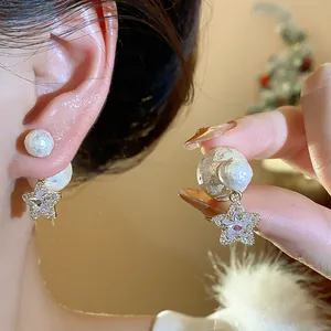 Detailansicht der Vintage-Sternohrringe mit Zirkonia-Steinen und einer weißen Perle.