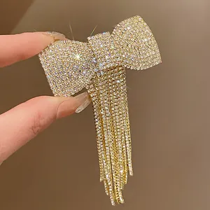 Detailed macro of a sparkling rhinestone bow hair clip with elegant long fringe tassels