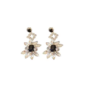 Elegant silver needle drop earrings featuring geometric flower design and black crystals.