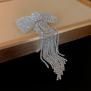 Detailed macro view of a sparkling rhinestone bow hair clip with elegant long tassels