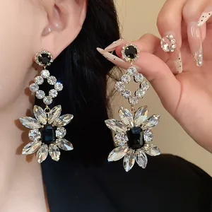 Detailed view of luxury rhinestone flower rhombus dangle earrings with black crystals