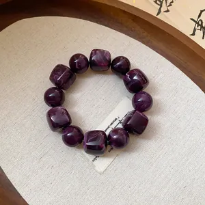 Close-up of purple marbled acrylic bracelet with alternating round and cube beads.