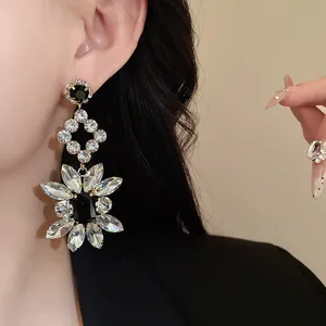 Detailed close-up of luxurious silver needle earrings with dazzling rhinestone flowers