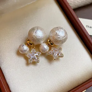 Nahaufnahme von eleganten vergoldeten Sternohrringen mit Perlen und Zirkonia