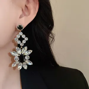 Detailed view of elegant silver needle rhinestone flower earrings with black stones