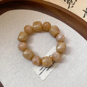 Detailed macro view of acrylic geometric beaded bracelet with warm marble texture
