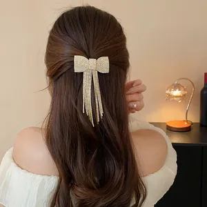Macro detail of a sparkling rhinestone bow hair clip with long elegant tassels on hair
