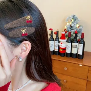 Fuzzy brown triangular hair clips with cherry bow charms worn by model