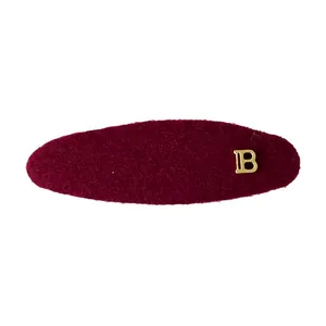 Elegant burgundy plush hair clip with golden metal B logo for women autumn winter style